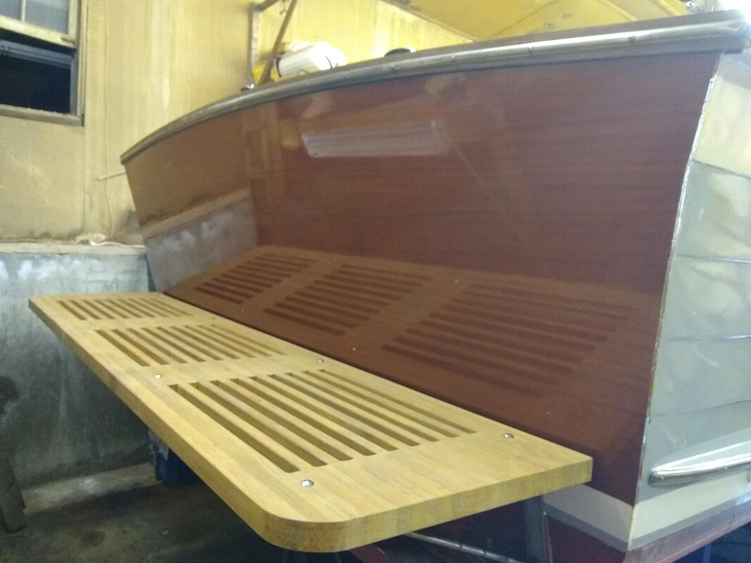 Varnished wooden transom and teak swim platform of a downeast style power boat completed by south shore boatworks
